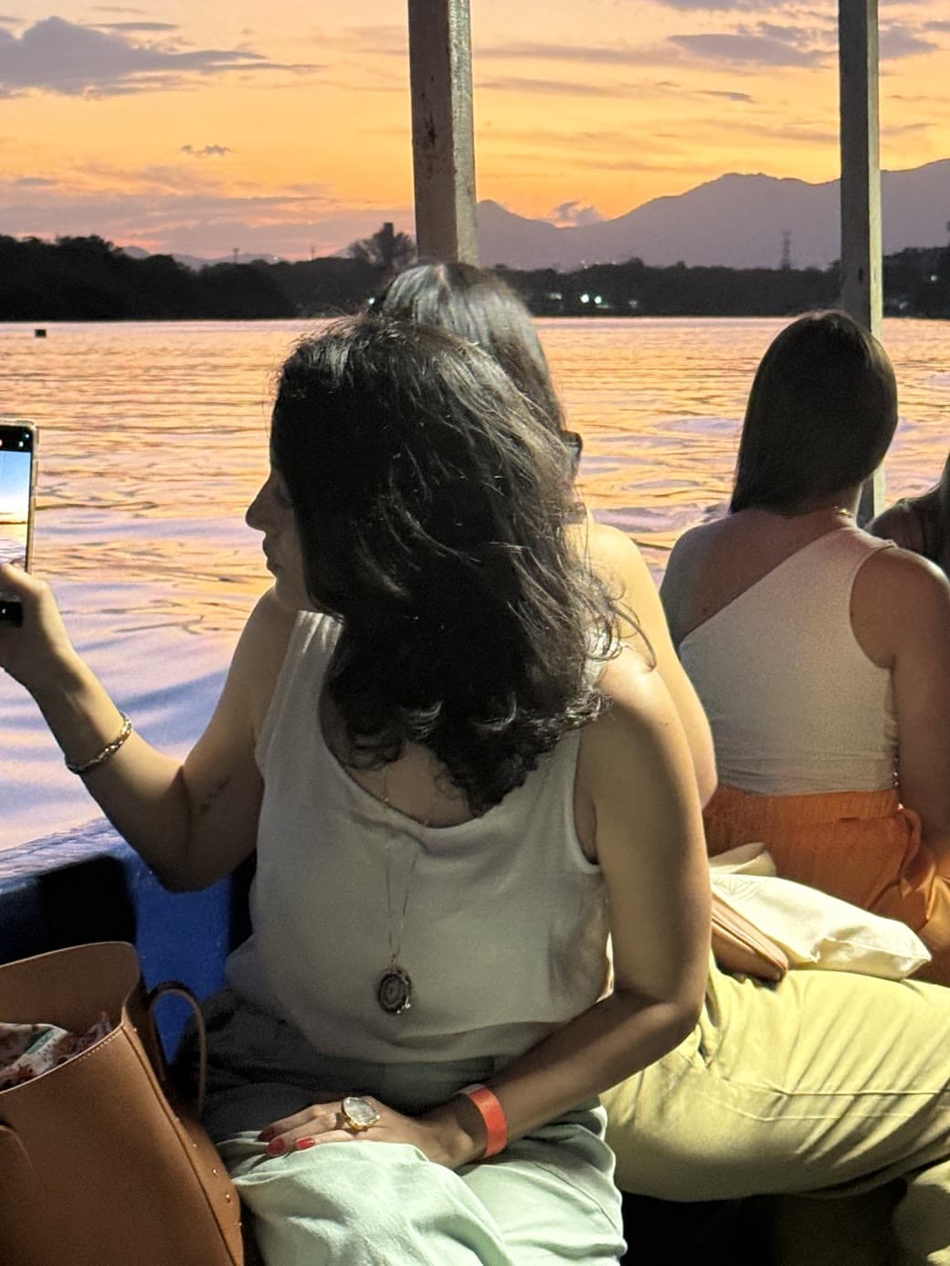 Mentoradas no barco olhando o pôr do sol no rio